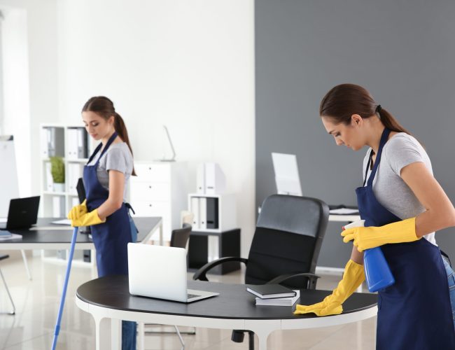 Team of janitors cleaning office